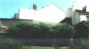 The farmhouse today, partly obscured by bushes